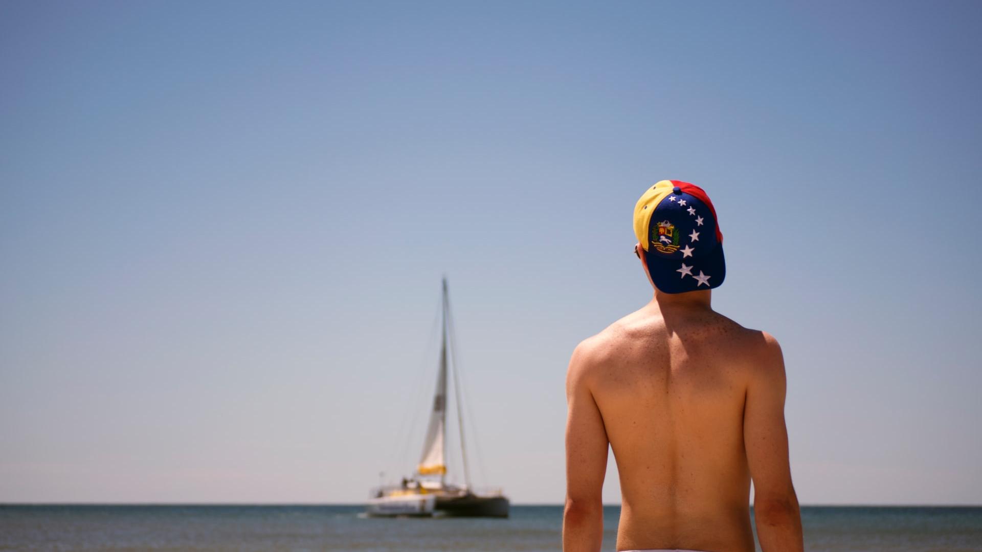 man standing facing boat during daytime