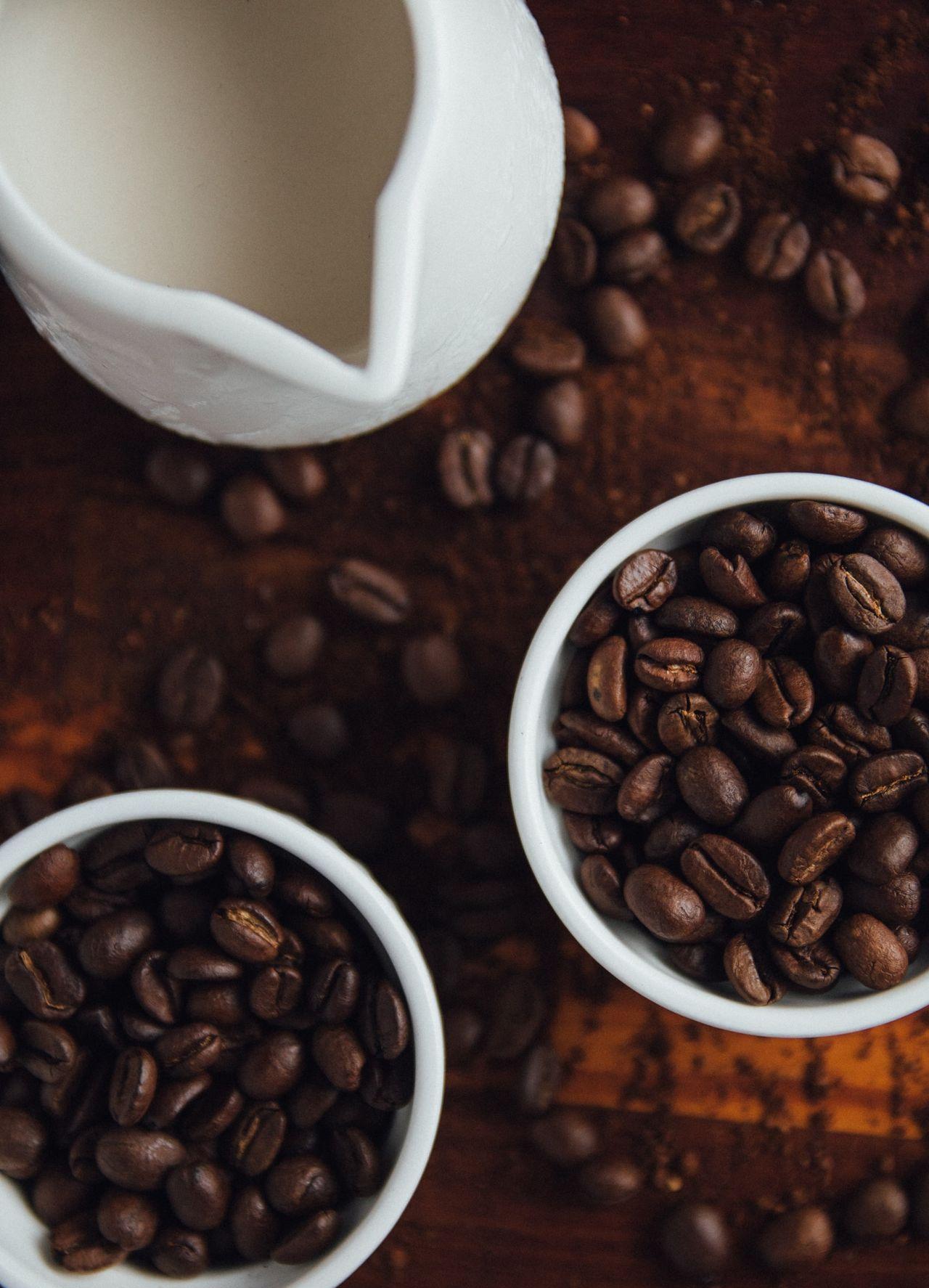 black coffee beans in ceramic mugs